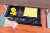 overhead view of the under desk tray attached to the desk, hand pulling out tray, pads, pens, pencils